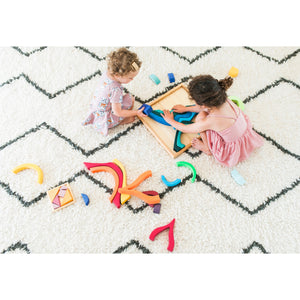 two girls playing with the large four elements building set on a carpet