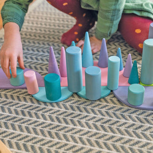 children playing with large pastel semicircles, building a scene