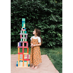 child stands next to structure taller than herself; built from the large stepped pyramid