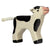 A calf wooden figure painted white with black spots, black hooves, and a pink nose.