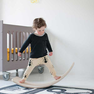 Boy standing on and rocking the wobbel board