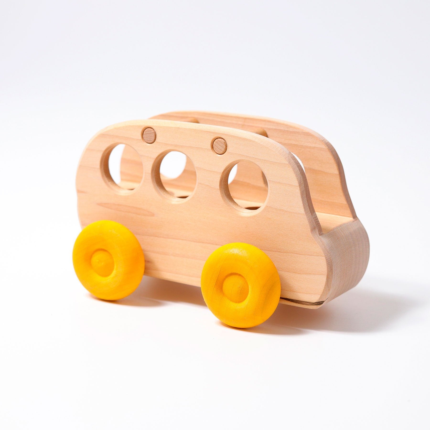A wooden natural bus with yellow wheels. Side view.