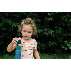 child stacking the cubes of the large stepped pyramid