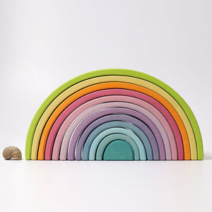 large pastel rainbow; front view, sea shell sitting next to it