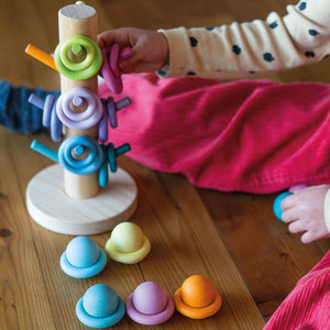 child matching building rings to the corresponding dowels