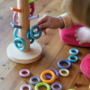 child matching building rings to the corresponding dowels
