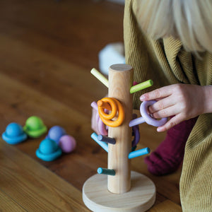 child matching building rings to the corresponding dowels