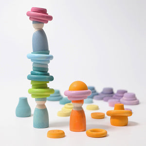 pastel building rings being used to stack people and balls on top of each other