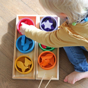 child playing with rainbow bowls sorting game