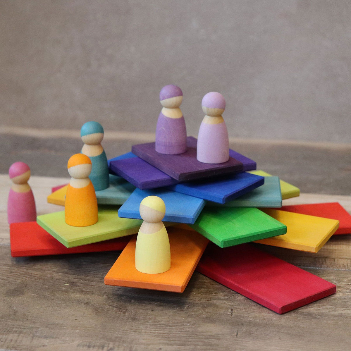rainbow building boards stakced on top of each other with peg people on top
