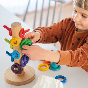 child matching building rings to the corresponding dowels