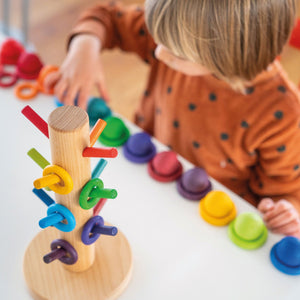 child playing with the rings, sort, and rainbow balls