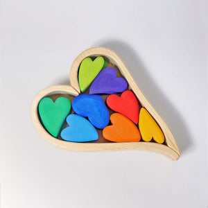Small tinted wooden hearts in a natural (non-tinted) wooden heart shape frame. The frame consists of two wooden pieces that for a heart and heart-shaped tray. Tint colors of the small hearts are: lime green, green, baby blue, royal blue, purple, red, orange, and yellow.