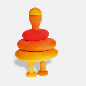 image of the orange mushroom bottom flipped over with the orange mushroom capon top to form a head. The head sits on a body made from the fire pebbles. The body sits on top of two legs made from two orange bobbins.
