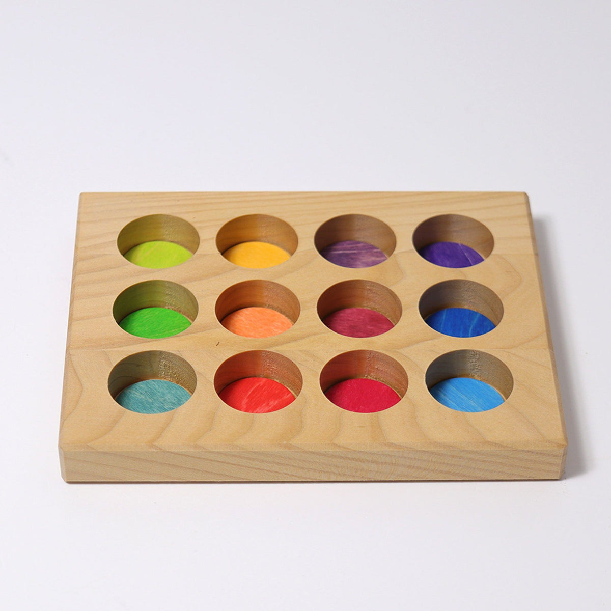The rainbow sorting board is made from one solid piece of wood with 12 holes removed. Each hole is painted a rainbow color that matched the rainbow friends and small rainbow balls. Colors include: lime green, green, teal, yellow, orange, bright red, dark red, maroon, dark purple, bright purple, royal blue, and baby blue.