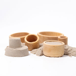 natural wooden bowls being used to shape sand