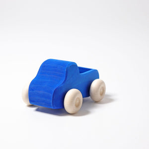 A wooden truck painted blue with natural wheels. Front view.