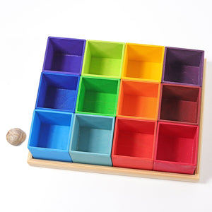 12 rainbow boxes in a natural wood frame. The colors of the boxes match the Grimm's rainbow sets.