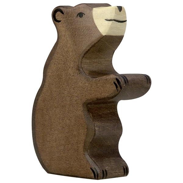 A small bear wooden figure painted brown with a white nose/mouth and dark paint used for face and claw detailing. The bear is sitting on its bottom with two arms in the air.