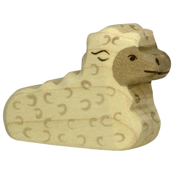 A wooden lamb figure laying. There are no legs so that the lamb is laying wherever you set it down.