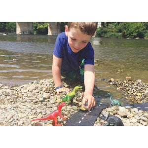 Image of a boy with with the track near a river. The track goes from a rocky surface into the water.